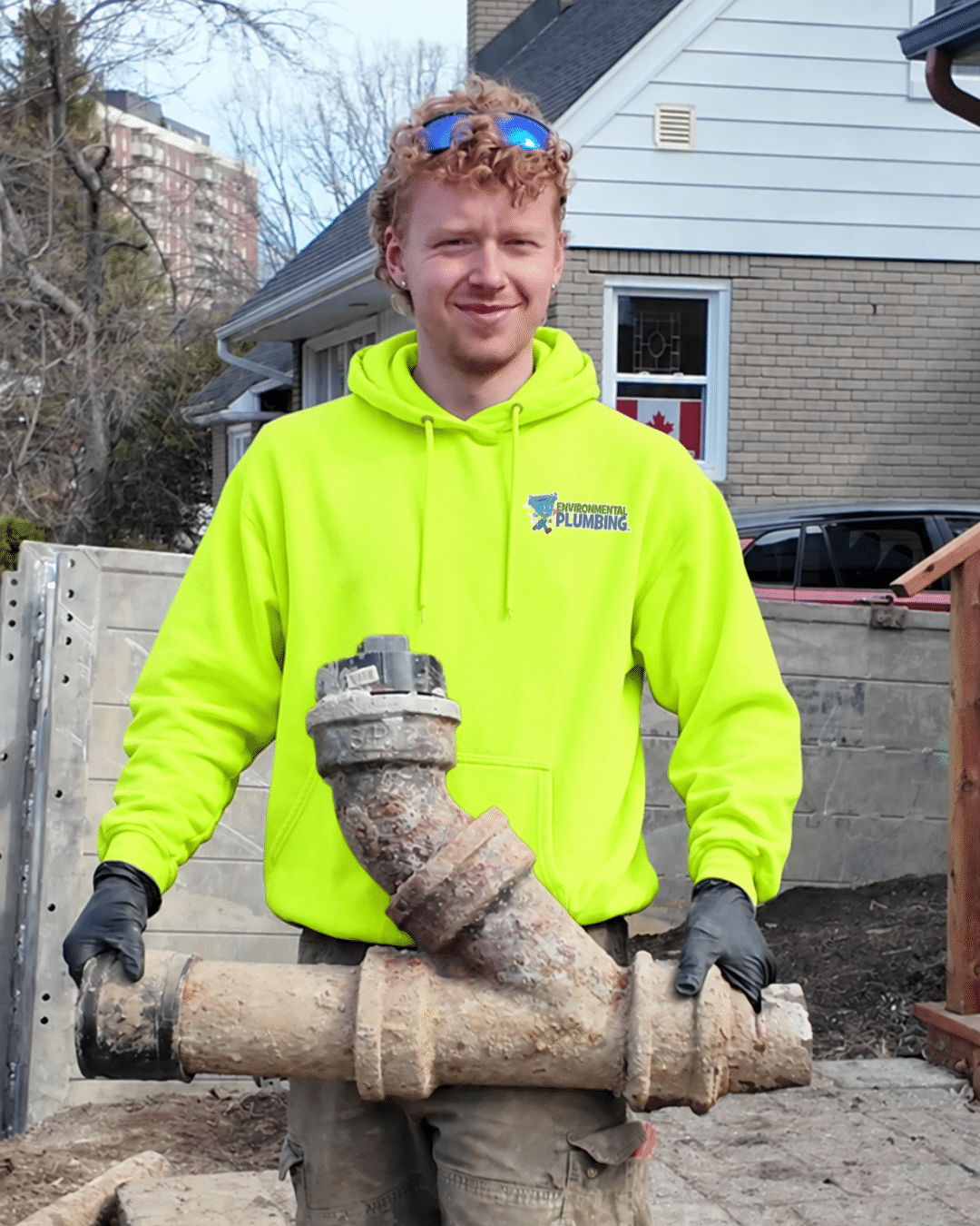 Environmental Plumbing plumber holding an old sewer pipe removed during a sewer lateral replacement