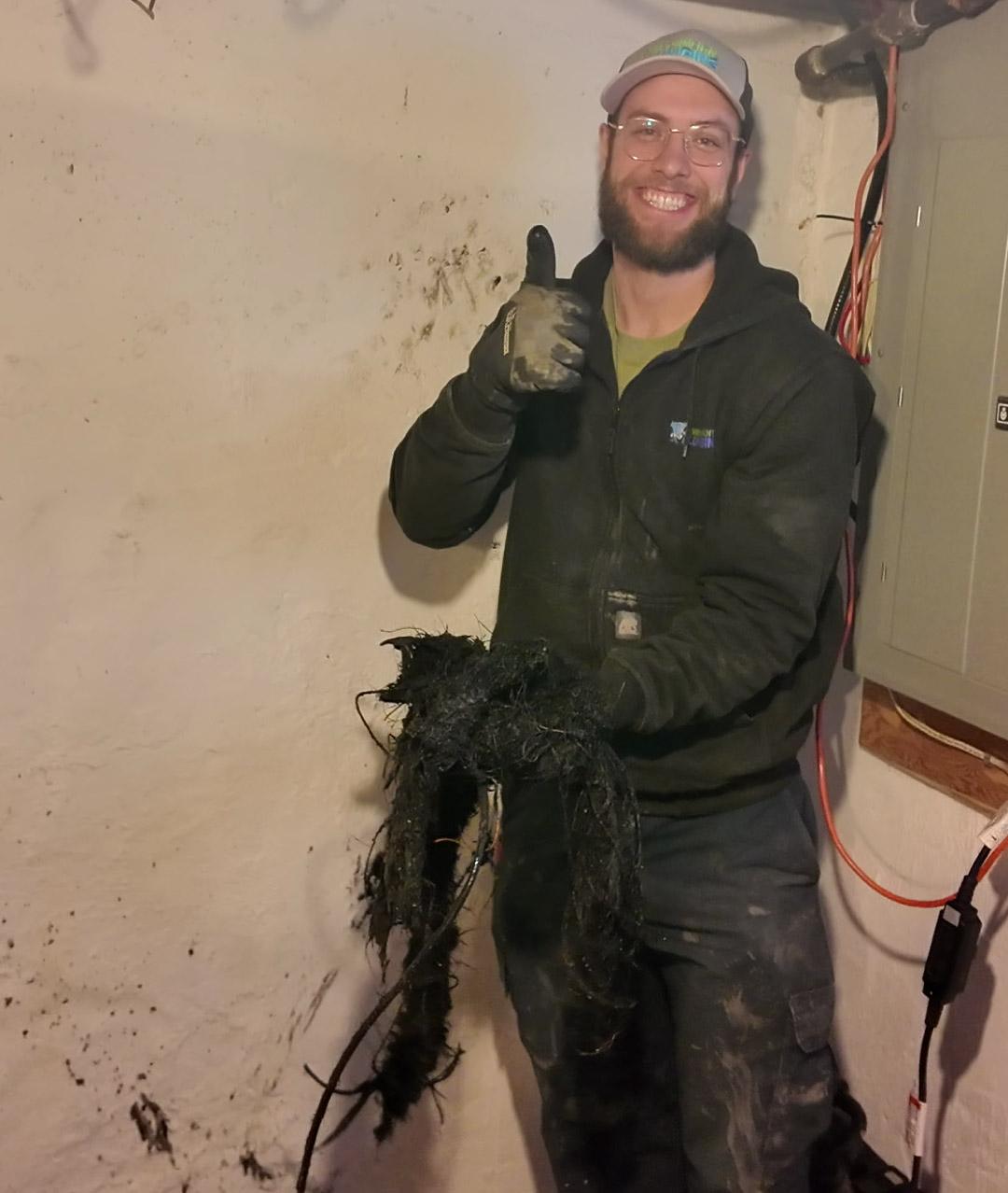 Environmental Plumbing plumber after clearing tree roots from a drain