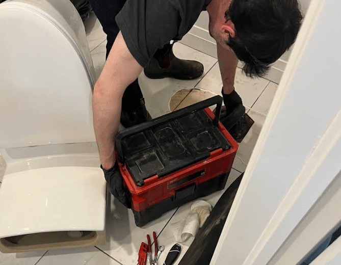 Plumber working on a stubborn toilet clog in Kanata